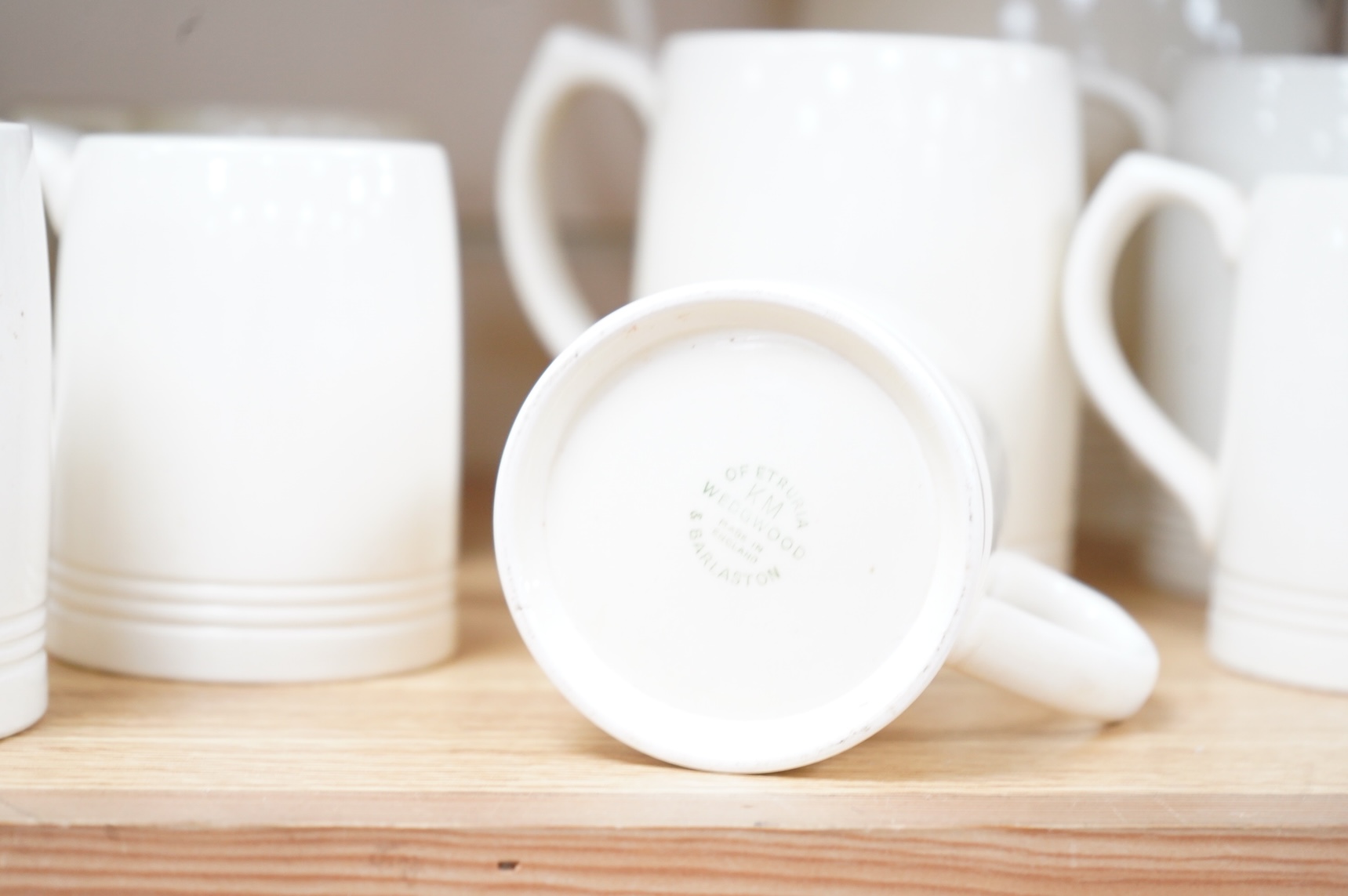 Keith Murray for Wedgwood, a cream lemonade jug, five small mugs, two large three faceted, largest 21cm high (12)